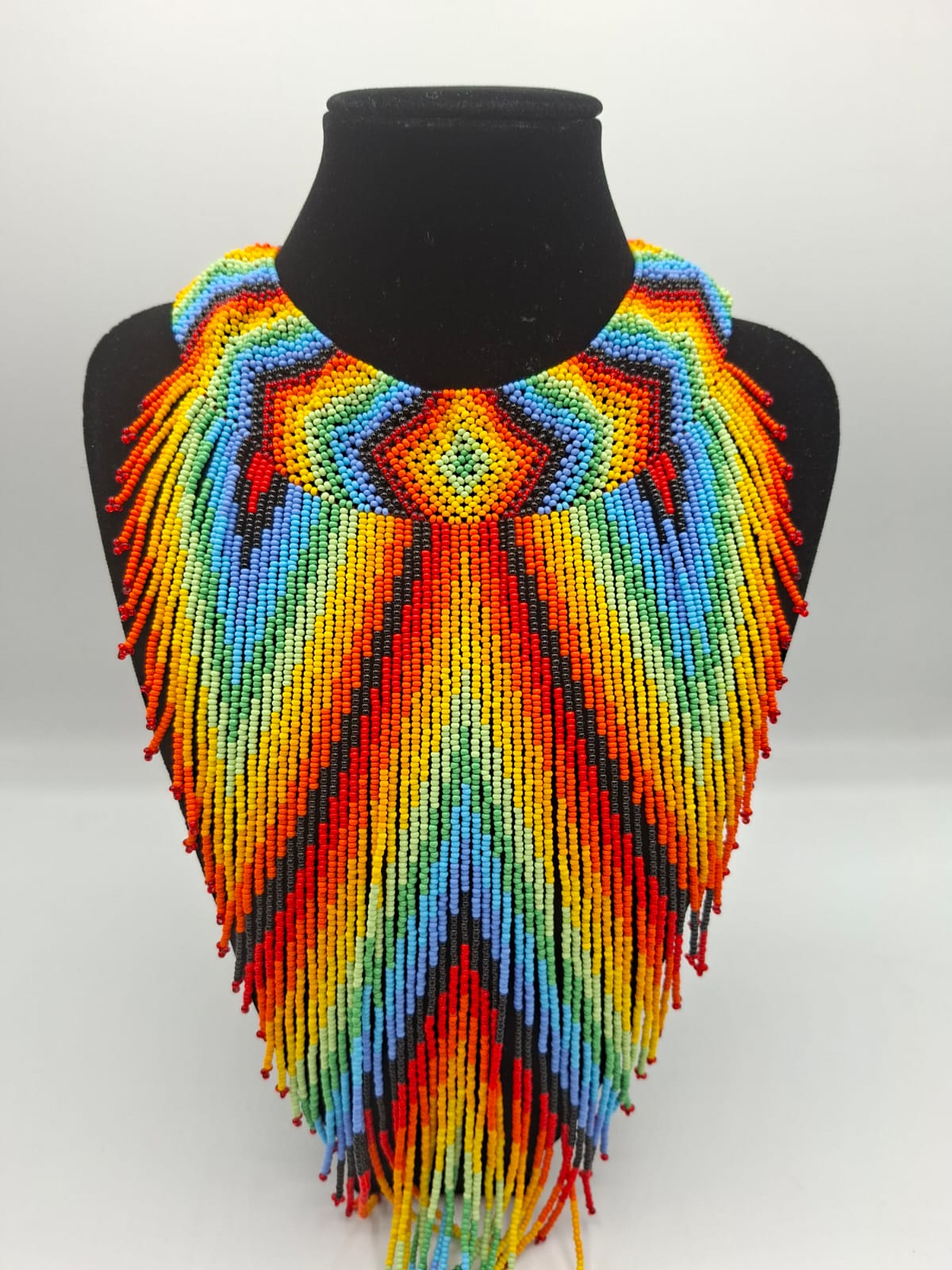 Collar artesanal en chaquira tejida a mano con patrones geométricos multicolor