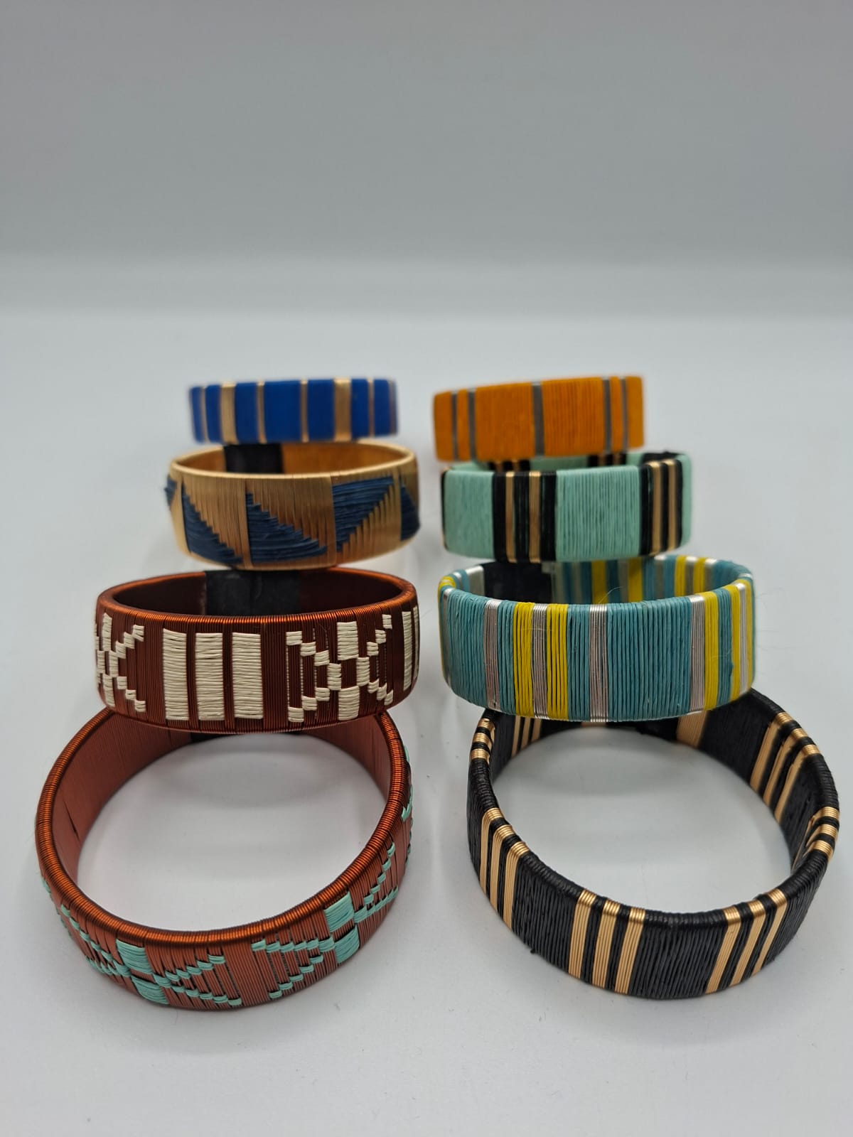 Pulseras artesanales tejidas en fibra con hilos dorados